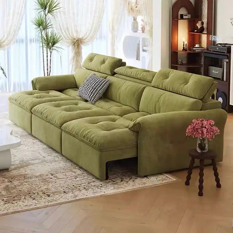 green pull-out sofa bed with raised head pillows and lounge cushions