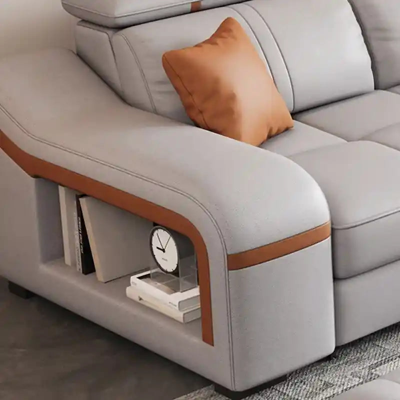 Close-up of Maelis grey sofa bed showing armrest side shelf, orange accent detail, and practical storage shelf design