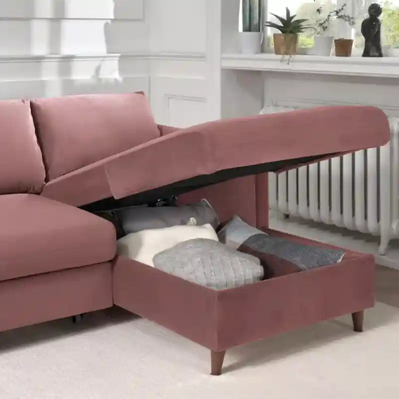 Close-up of  pink sofa bed showing padded armrest, fabric finish, and tapered wooden leg
