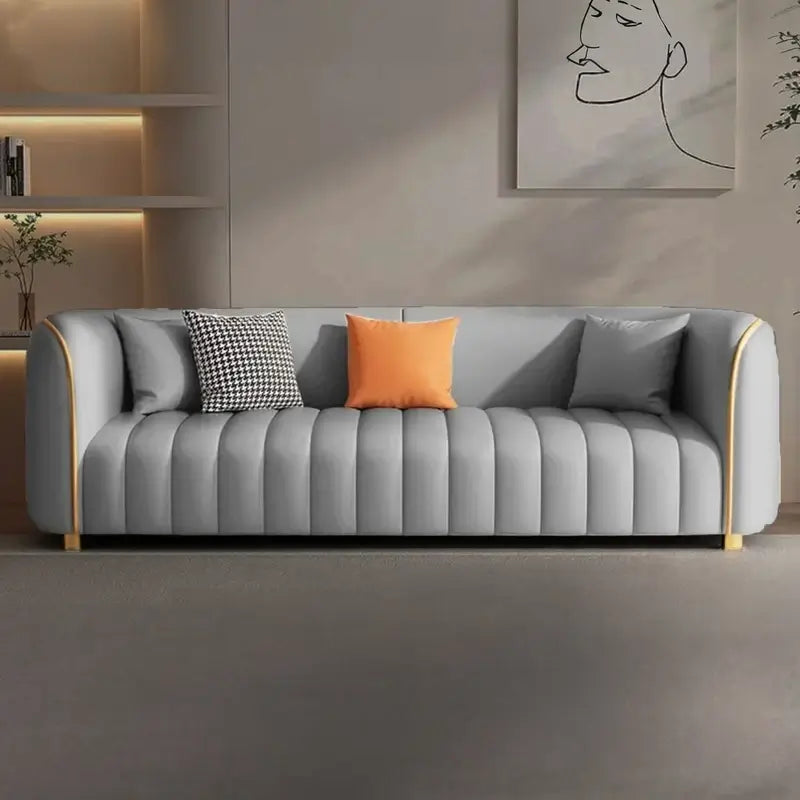 Luxury living room sofa with ivory upholstery, slim gold legs, plush cushions, and premium designer finish