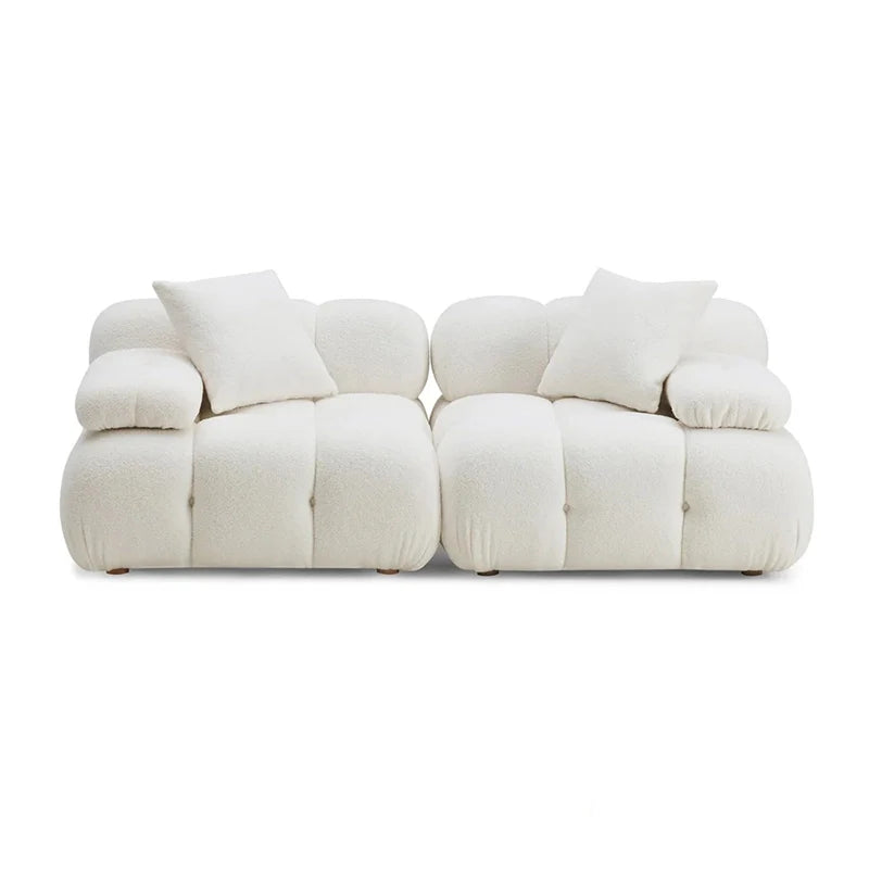 White sofa with multiple cushions on a white background