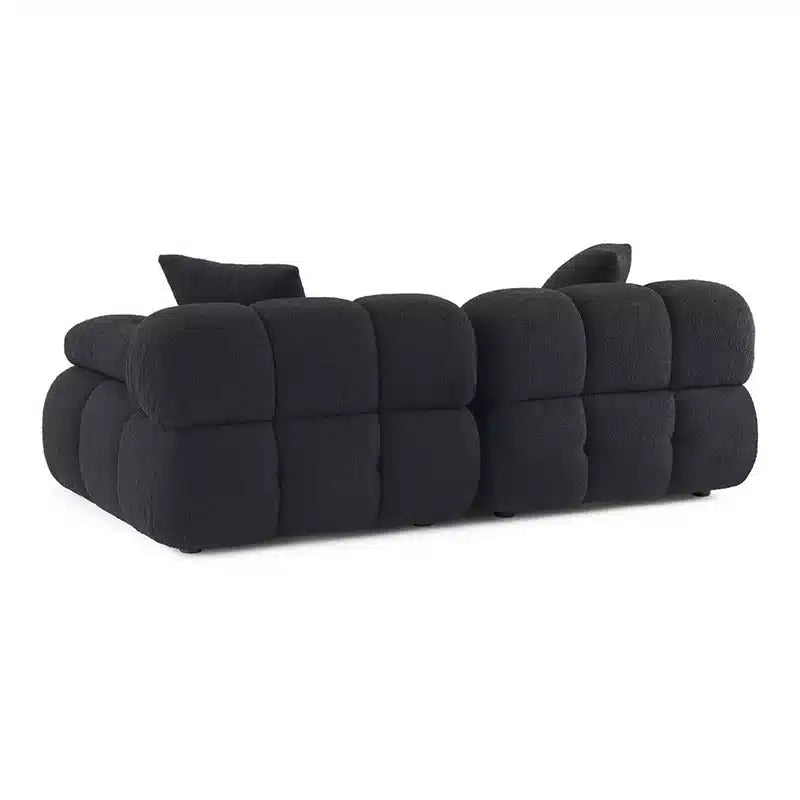 This contemporary sofa design features deeply tufted cushions, pillow-like armrests, and soft rounded edges that define both comfort and style. 