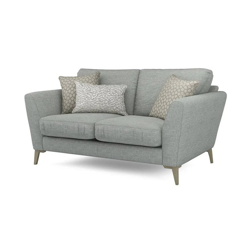 Tapered legs in wood and metal finishes elevate its visual lightness while plush cushions ensure ergonomic comfort.