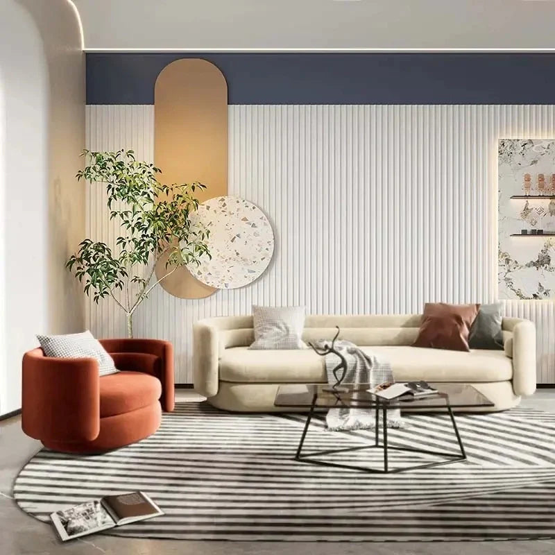 Sculpted cylindrical arms and a soft wraparound back create a grounded silhouette ideal for high-end living rooms.