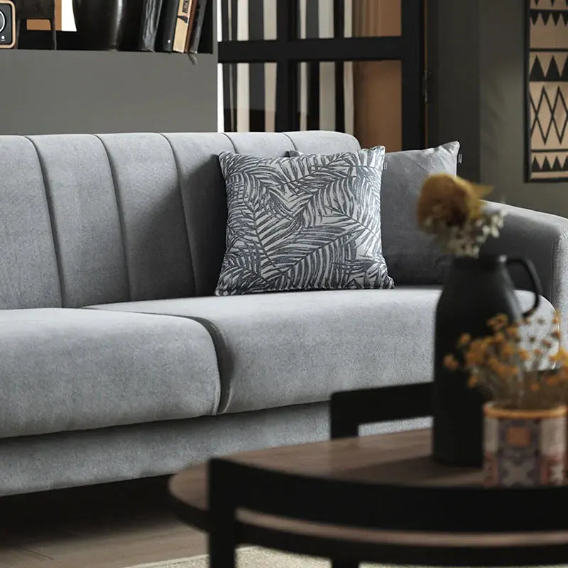 Gray sofa with two decorative pillows on a white background